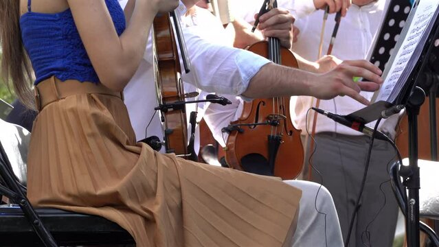 Close up of a string quartet getting ready to play outside