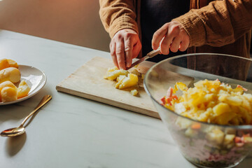 Man cutting potatoes for salad at kitchen