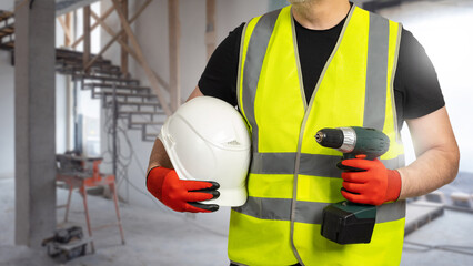 Fototapeta premium Man repairman. Guy in building under construction. Foreman with electric screwdriver. Man builder with helmet. Cropped repairman stands indoors. Construction crew worker in yellow vest