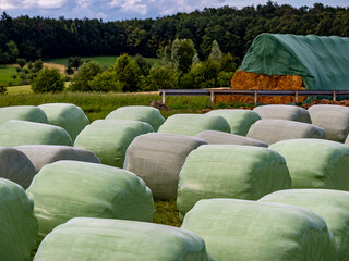 Heu und Silageballen lagern vor einer Scheune