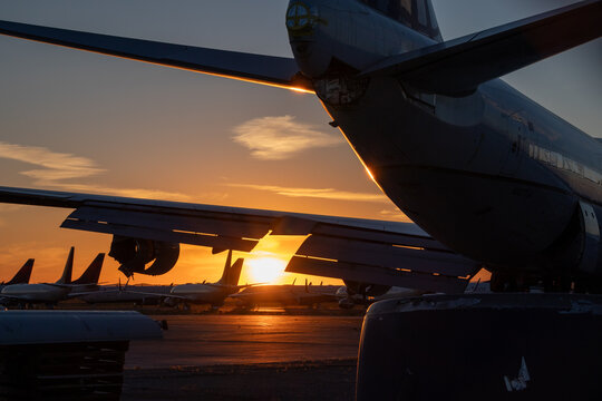 empennage and wing silhouette of an airplane during sunset at airport 