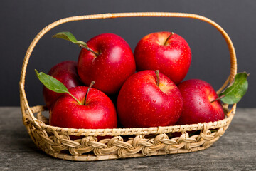 Ripe garden apple fruits with leaves in basket on wooden table. Top view flat lay with copy space