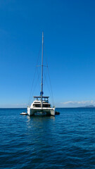 Obraz premium The catamaran is parked at sea. View of a catamaran with lowered sail on the open sea.