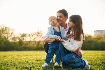 Fototapeta premium Mother with daughter and son are together on the field