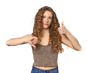 Simple redhead studio portrait showing thumbs up and thumbs down, difficult choose concept