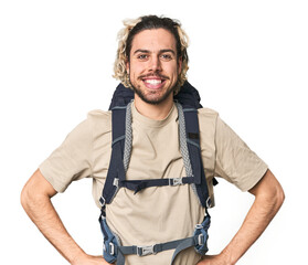 Young Caucasian hiker with backpack confident keeping hands on hips.