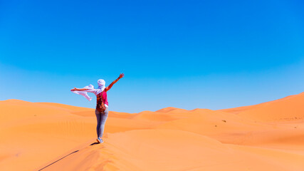 Happy woman tourist in the desert with blue sky- Adventure, travel, tourism