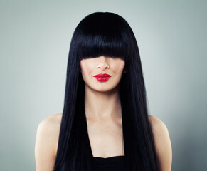 Fashionable young model woman with long healthy dark straight smooth hair and make-up, studio...