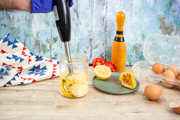 Mayonnaise preparation in a glass jar with a immersion vertical blender, soft focus close up