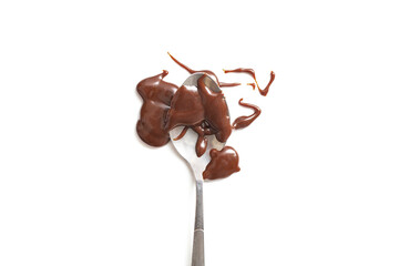Chocolate melted, smudged and splashed over a tea spoon isolated on white background