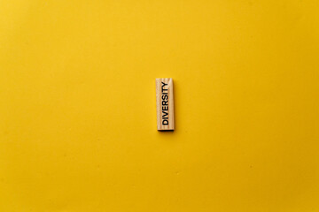 a yellow warm background without shadows wooden cubes with black letters laid out word diversity