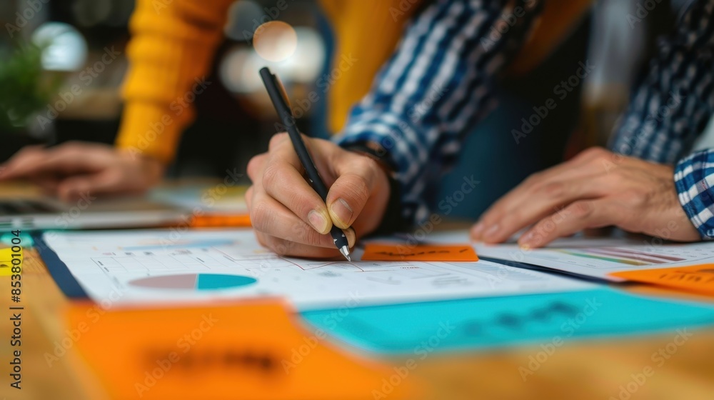 Poster close-up view of hands analyzing and pointing at financial business charts on a table