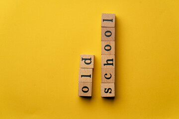 a yellow warm background without shadows wooden cubes with black letters laid out word old school