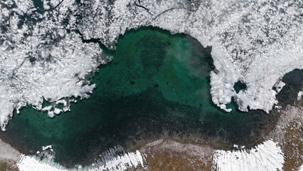 Wonderful pictures of the blue water of the dragon lake, still slight remains of ice on the surface, surrounded by high mountains that are still a little snow-covered 