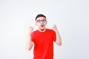 Naklejka premium Excited young Asian man clenched fist showing excitement during celebrating indonesian independence day on 17 august isolated on white background