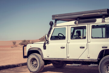 White off road car in the middle of desert on a hot sunny day