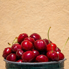 Fresh cherries on a peach background, a healthy eating concept, with space for text