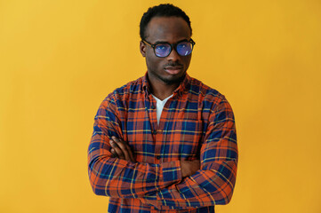 Obraz premium Standing and posing. Black man is in the studio against yellow background