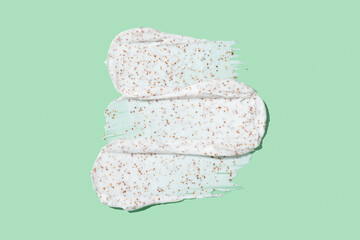 Smears of body scrub on green background. Fruit and berry body scrub texture of the swatch. Cosmetic smear