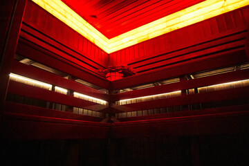 A modern sauna with red lighting and wooden walls
