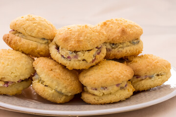 stuffed cookies. a stack of lush cookies with filling lies on a white plate, close-up top view sweet concept
