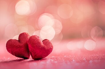 Obraz premium Two red hearts on a pink background with copy space for Valentine's Day celebration