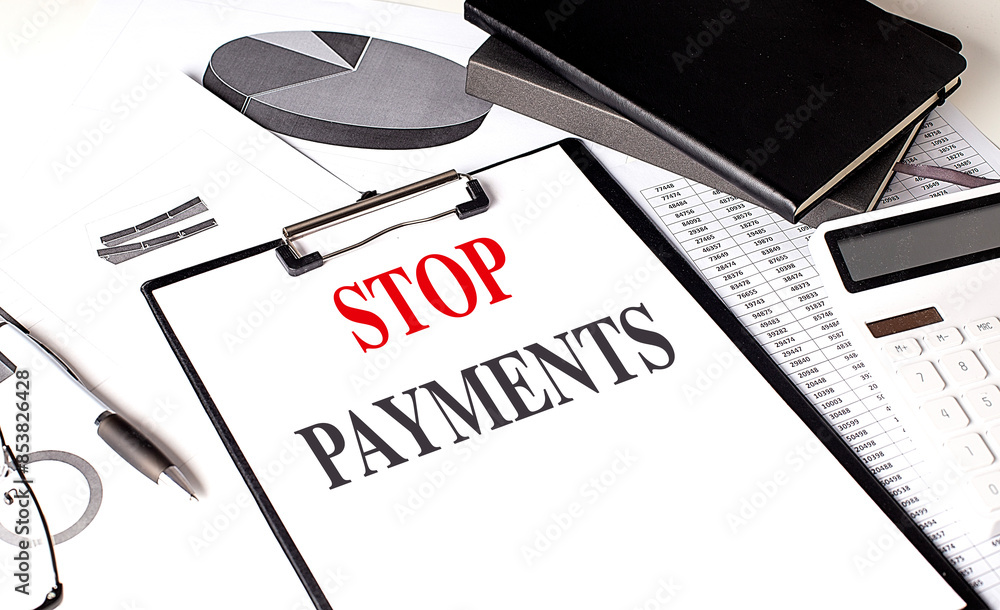 Poster stop payments text on clipboard on chart with notebook and calculator