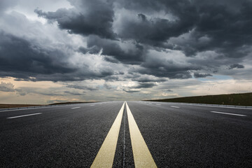 Straight highway road with black rain clouds natural landscape before the rainstorm