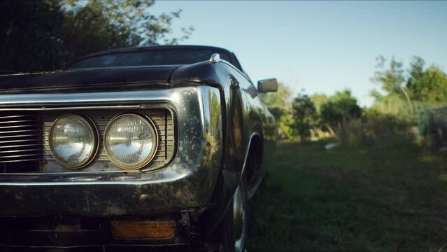 Front view of an Old car parked on a farm