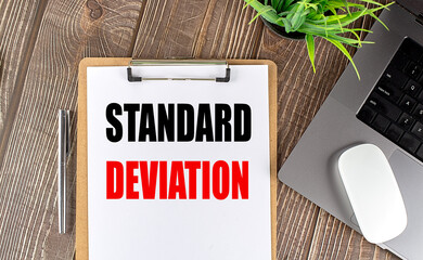 STANDARD DEVIATION text on clipboard paper with laptop, mouse and pen
