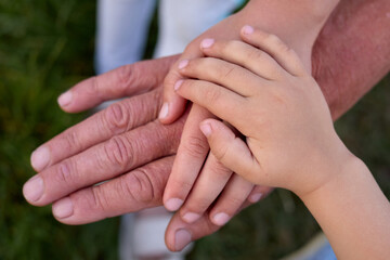 Closeup of old man and child's hands grandfather and his grandchildren holding hands generation of family