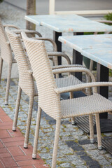 Wicker or rattan chairs and tables on fresh air in outdoor restaurant or cafe in city of center