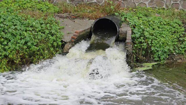 Waste water sewage from a pipe into the river. Water pollution, environment contamination concept