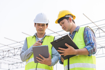 Builder team, foreman asian young engineer, architect man, male are discussing construction drawing on blueprint follow project to build an industrial plan at outdoor site. Engineering worker people.