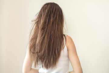 Damaged hair, frustrated asian young woman, girl in splitting ends, messy unbrushed dry hair and frizzy with long disheveled hair, health care of beauty. Portrait isolated on background, Back view.