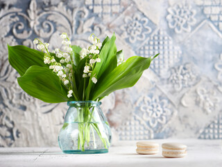 bouquet of flowers lilies of the valley and macaroons dessert