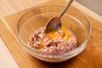 An egg and greens are added to the minced meat. Minced meat for cooking fried meat cutlets.