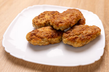 Freshly fried cutlets are placed on a plate.