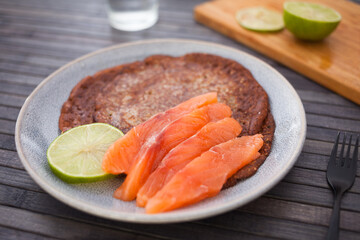 Salted salmon fillet with buckwheat pancakes and lime