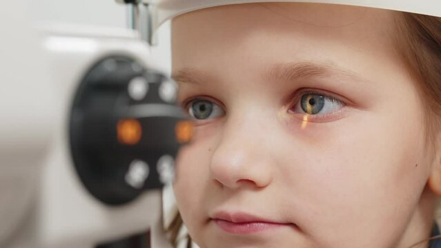Examination of the child using a slit lamp. Microscope and focused light source. A device for high-precision examination of the eye to determine the condition of the lens.