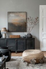 A black and white framed painting hangs on a wall above a black