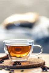 Close-up, glass cup of aromatic black tea on a blurred background.
