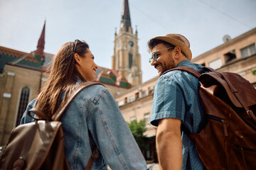 Below view of happy couple of tourists walking in  town. © Drazen