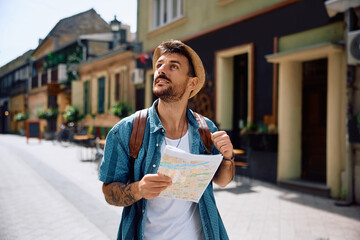 Smiling traveler enjoying in exploring city during his journey.