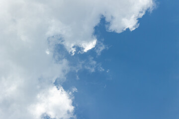 Background of bright blue sky with white fluffy clouds on it