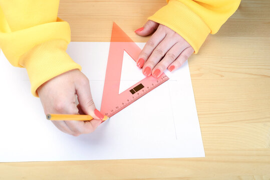 Drawing lines with a pencil and triangular ruler.