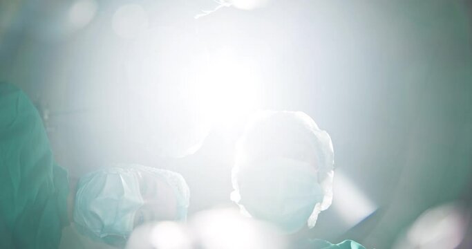 Patient, pov and doctors with surgery in theater with tools, check or help in emergency room with low angle. Surgeon, team and people for collaboration in ppe for safety, hygiene or service at clinic