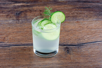 Cucumber refreshing drink glass with cucumber circles and decorated with dill.