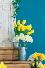 A bouquet of yellow tulips in a shoe vase, a spring bright photo zone in a photo studio.