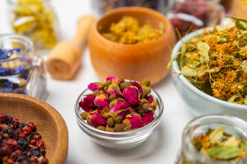 Assortment of dry herbal and berry tea on a wooden background. Tea party concept. medicinal herbs. Healing herbs.Alternative medicine.Linden, calendula, cornflowers, marigold, tansy, tea rose.